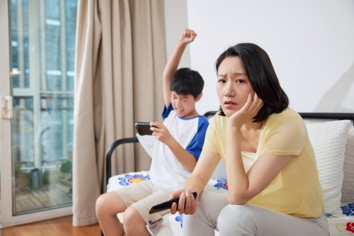 摄图网_507720509_玩手机的孩子和烦躁的母亲（企业商用）.jpg